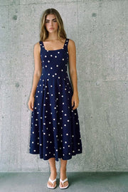 Vestido midi de corte en a, tirantes, estampado de lunares, escote cuadrado y cortes decorativos. Cierre lateral con cremallera oculta.