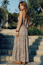 Vestido midi strapless de estampado floral, escote recto, cut out en espalda con nudo amarrable, cintura elástica, detalle de capas de olanes en bajo y fruncido en espalda.