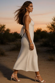 Vestido midi de fit recto, escote curveado con detalles plisados y corte frontal, tirantes delgados ajustables y cut out con nudo en espalda. Cierre posterior con cremallera oculta.