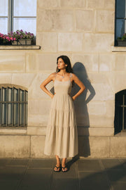 Vestido midi de lino, corte en a, tirantes delgados con nudo amarrable, bajo con capas de olanes, cut out en costados y espalda. Detalle de rib elástico en cintura y fruncido en espalda.