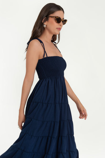 Vestido midi de talle fruncido, escote recto, tirantes delgados con nudo amarrable, corte en a y bajo con capas de olanes.