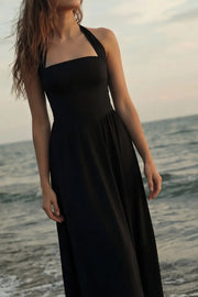 Vestido midi de cuello halter, sin mangas, escote recto, corte en a, corte v en cintura con plisados y fruncido en espalda.