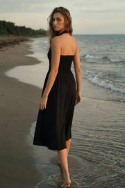 Vestido midi de cuello halter, sin mangas, escote recto, corte en a, corte v en cintura con plisados y fruncido en espalda.