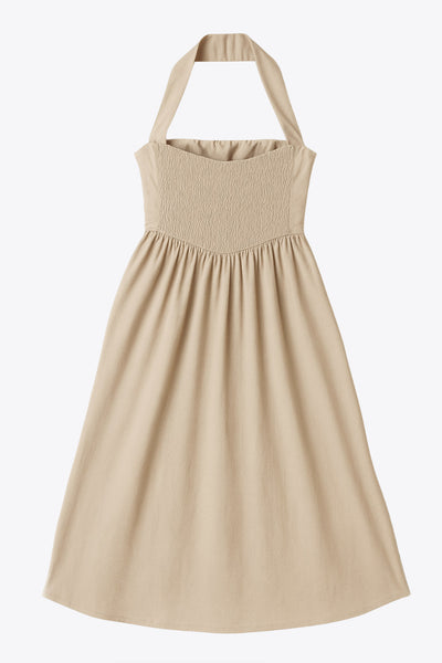 Vestido midi de cuello halter, sin mangas, escote recto, corte en a, corte v en cintura con plisados y fruncido en espalda.