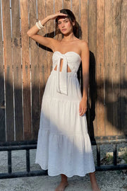 Vestido midi strapless de escote corazón con nudo amarrable, cut out frontal, cintura elástica, detalle de capas de olanes en bajo y fruncido en espalda.