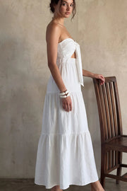 Vestido midi strapless de escote corazón con nudo amarrable, cut out frontal, cintura elástica, detalle de capas de olanes en bajo y fruncido en espalda.