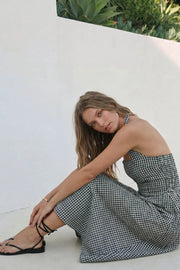 Vestido midi de estampado cuadros, cuello halter con rib elástico, sin mangas, escote recto, cortes frontales, detalle frontal v en cintura con plisados y fruncido en espalda.