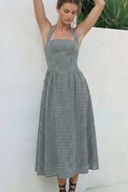 Vestido midi de estampado cuadros, cuello halter con rib elástico, sin mangas, escote recto, cortes frontales, detalle frontal v en cintura con plisados y fruncido en espalda.