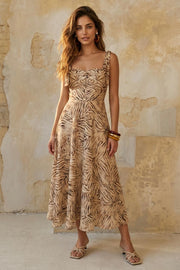 Vestido midi estampado de tirantes con nudo amarrable, escote corazón con plisados y cortes decorativos frontales, corte en a y cierre posterior con cremallera oculta.
