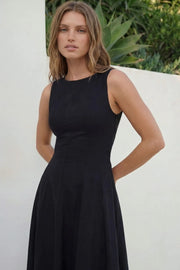 Vestido midi de lino, sin mangas, corte en a, cuello barco, escote en espalda y cortes frontales decorativos. Cierre lateral con cremallera oculta.