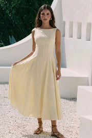 Vestido midi de lino, sin mangas, corte en a, cuello barco, escote en espalda y cortes frontales decorativos. Cierre lateral con cremallera oculta.
