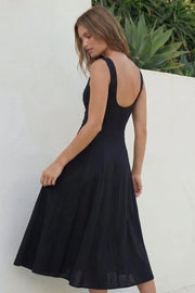 Vestido midi de lino, sin mangas, corte en a, cuello barco, escote en espalda y cortes frontales decorativos. Cierre lateral con cremallera oculta.