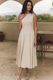 Vestido midi de lino, sin mangas, corte en a, cuello barco, escote en espalda y cortes frontales decorativos. Cierre lateral con cremallera oculta.