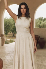 Vestido midi de lino, sin mangas, corte en a, cuello barco, escote en espalda y cortes frontales decorativos. Cierre lateral con cremallera oculta.
