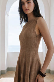 Vestido midi de lino, sin mangas, corte en a, cuello barco, escote en espalda y cortes frontales decorativos. Cierre lateral con cremallera oculta.
