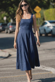 Vestido midi, sin mangas, corte en a, escote cuadrado y cortes decorativos. Cierre lateral con cremallera oculta.