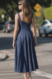 Vestido midi, sin mangas, corte en a, escote cuadrado y cortes decorativos. Cierre lateral con cremallera oculta.
