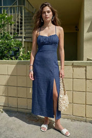 Vestido midi de fit recto, escote curveado con detalles plisados y corte frontal, tirantes delgados con cruce posterior y lazado ajustable en espalda. Abertura frontal en bajo y cierre posterior con cremallera oculta.