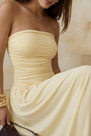 Vestido midi strapless, de escote recto, plisados en costados y corte en a con plisados en cadera.