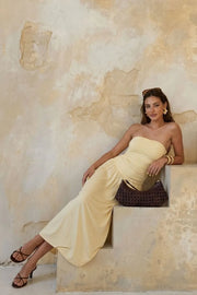 Vestido midi strapless, de escote recto, plisados en costados y corte en a con plisados en cadera.