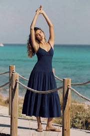 Vestido midi, tirantes delgados ajustables, escote v con cortes y plisados frontales, corte en a con plisados en cadera y capas de olanes en bajo. Detalle de cut out espalda con rib elástico y nudo amarrable posterior.