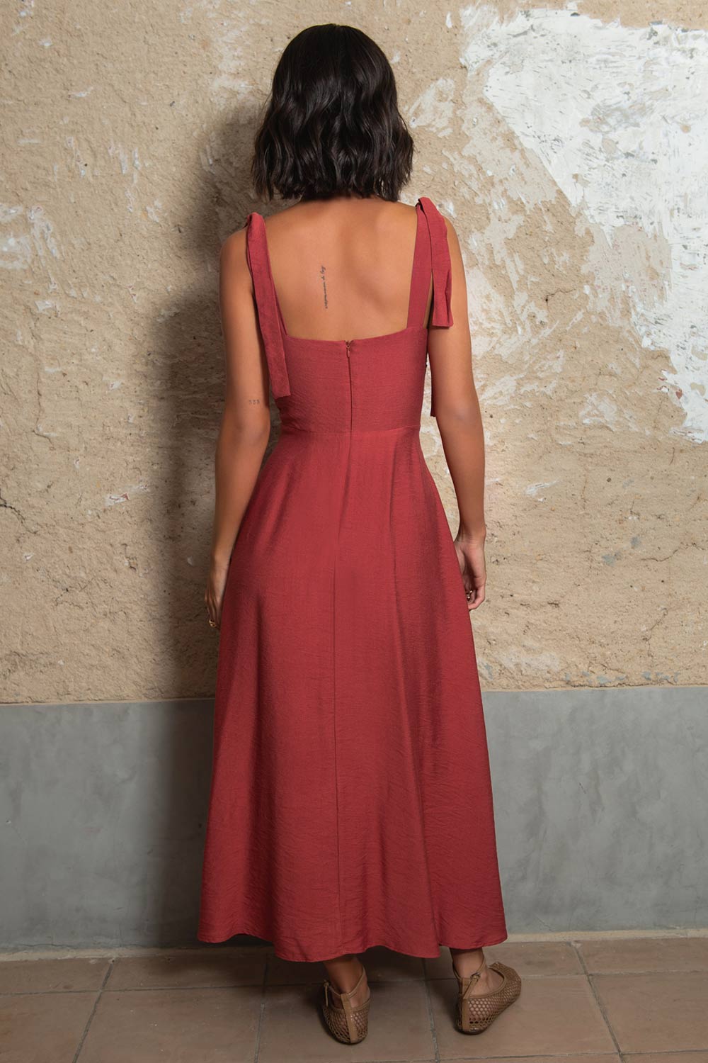 Vestido midi de tirantes con nudo amarrable, escote corazón con plisados y cortes decorativos frontales, corte en a y cierre posterior con cremallera oculta