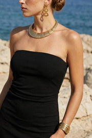 Vestido largo strapless, de fit ajustado, escote recto, plisados en costado, cierre posterior con cremallera oculta y abertura en bajo.