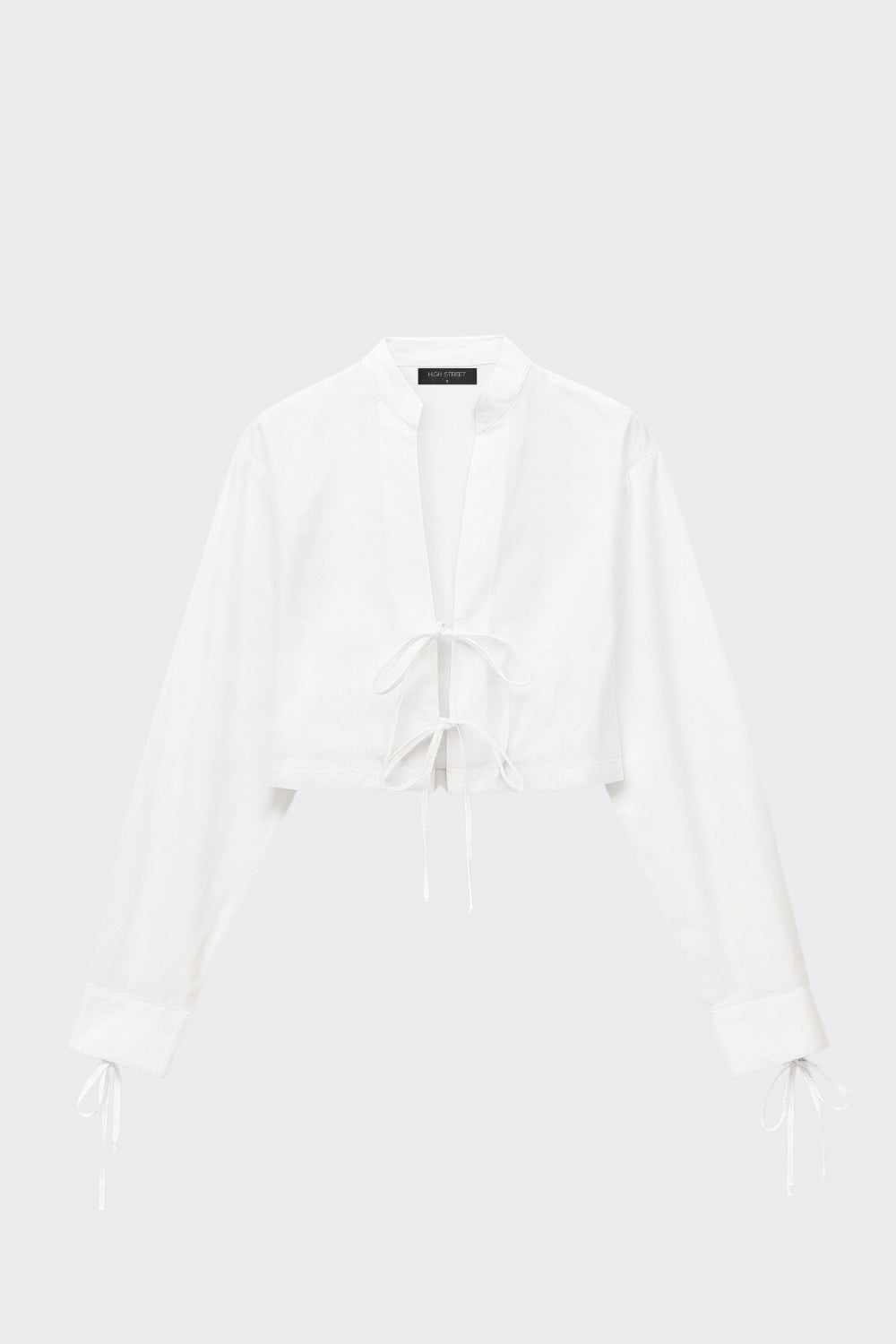 Camisa corta de fit recto, manga larga con puño y lazado decorativo, cuello mao y cierre frontal con lazado amarrable.