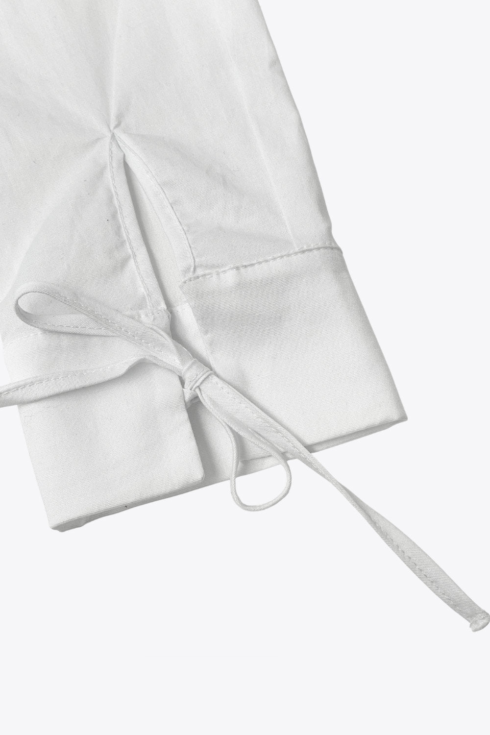 Camisa corta de fit recto, manga larga con puño y lazado decorativo, cuello mao y cierre frontal con lazado amarrable.