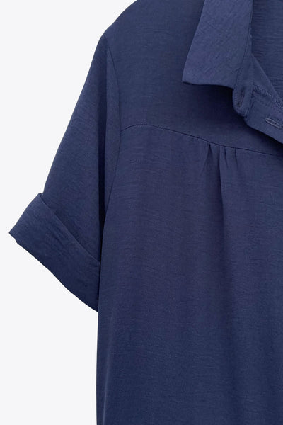 Maxi vestido camisero de manga corta con doblez en borde, cuello camisero, plisados frontales, olanes en bajo, jareta ajustable en cintura y cierre frontal con hilera de botones.