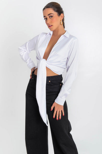 Blusa corta satinada de manga larga con puño abotonado, cuello camisero y escote v con nudo amarrable.