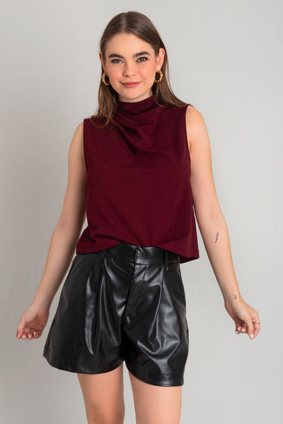 Blusa sin mangas de fit recto, cuello mock con detalles plisados y cierre posterior con botón y ojal.