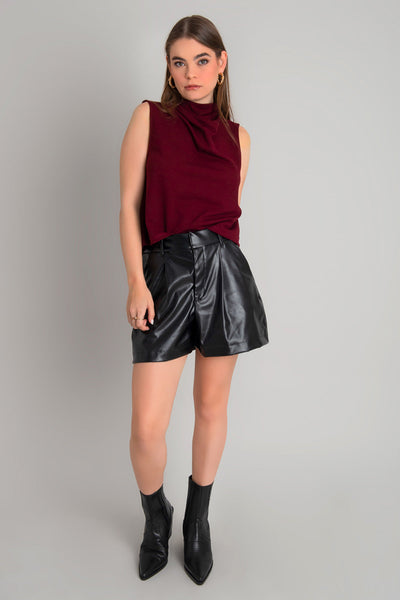 Blusa sin mangas de fit recto, cuello mock con detalles plisados y cierre posterior con botón y ojal.