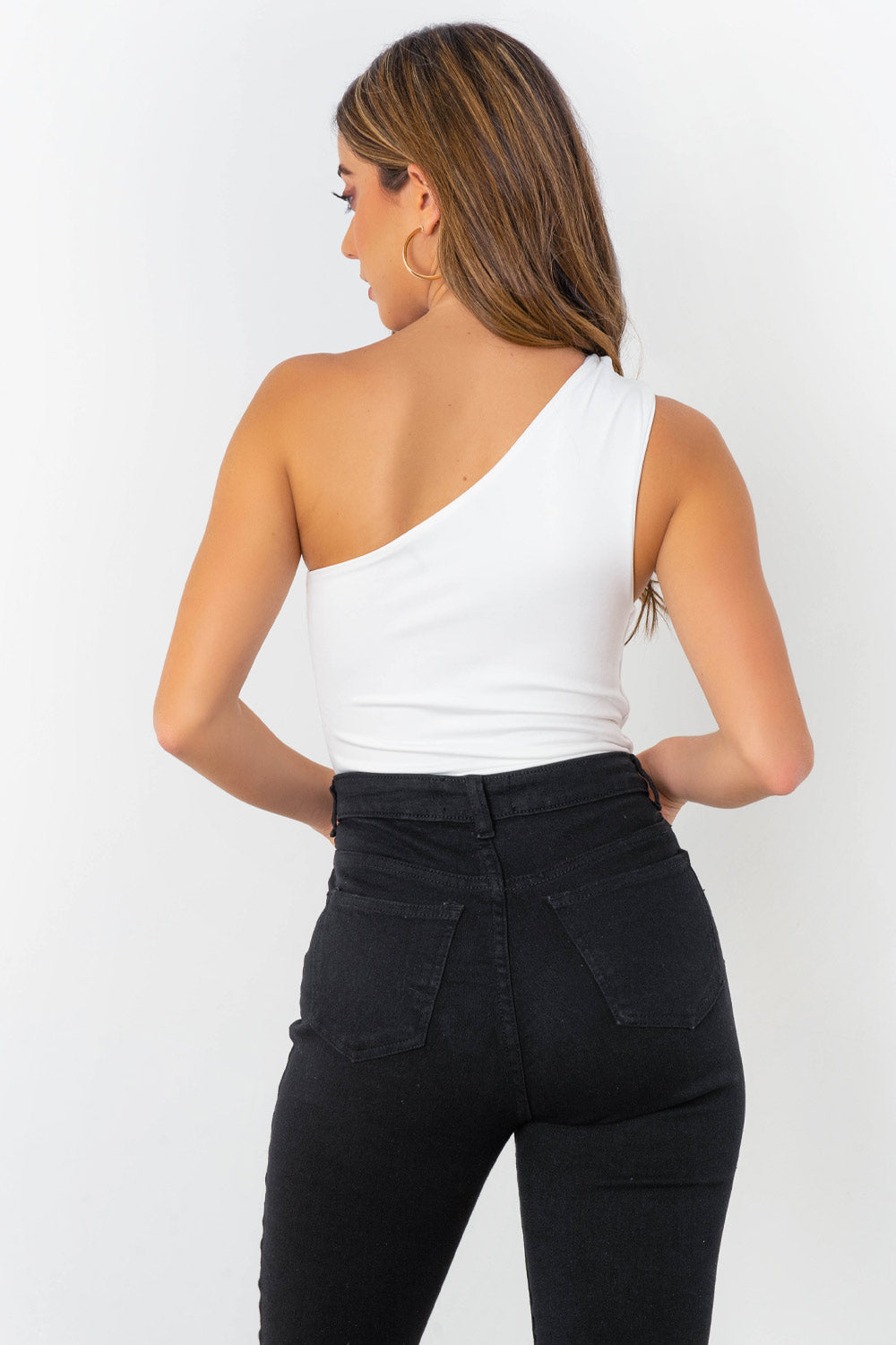 Body asimétrico de un hombro, fit ajustado, cierre inferior con broche de presión, detalles plisados en costado y hombro.