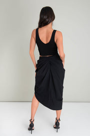 Falda midi de bajo curveado asimétrico, cintura alta, drapeado frontal con abertura y posterior con cremallera oculta.