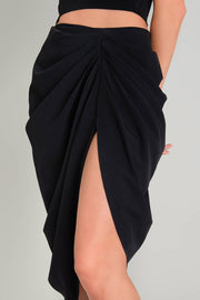 Falda midi de bajo curveado asimétrico, cintura alta, drapeado frontal con abertura y posterior con cremallera oculta.