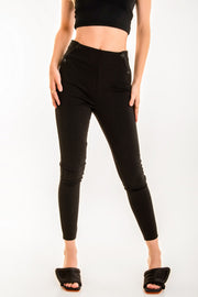 Legging de fit ajustado, cintura alta con pretina elástica y botones frontales decorativos.
